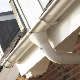 White Lindab Guttering on house with outlet.